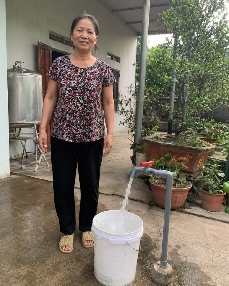 Khách hàng bên vòi nước và bồn chứa sau dịch vụ khoan giếng tại Cam Ranh, Khánh Hòa.